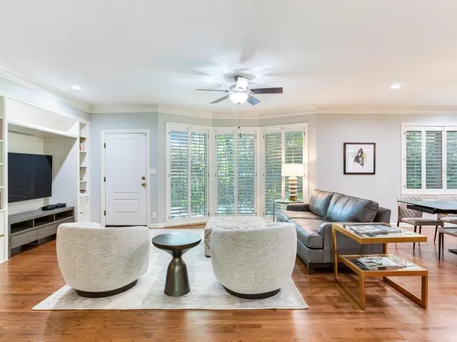a living room with couches and a flat screen tv with wooden floor