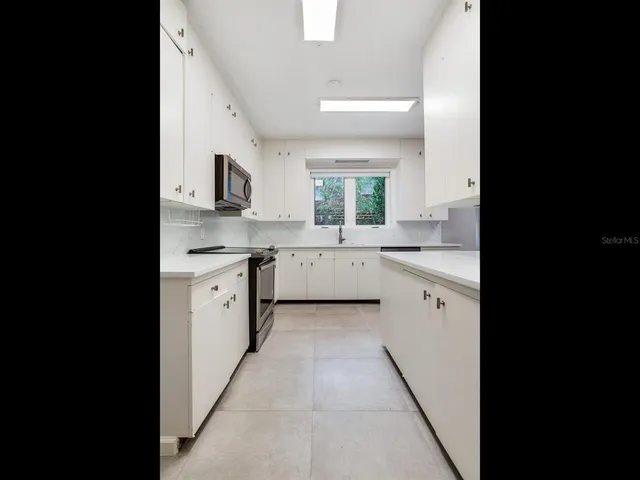 a large kitchen with a sink and cabinets