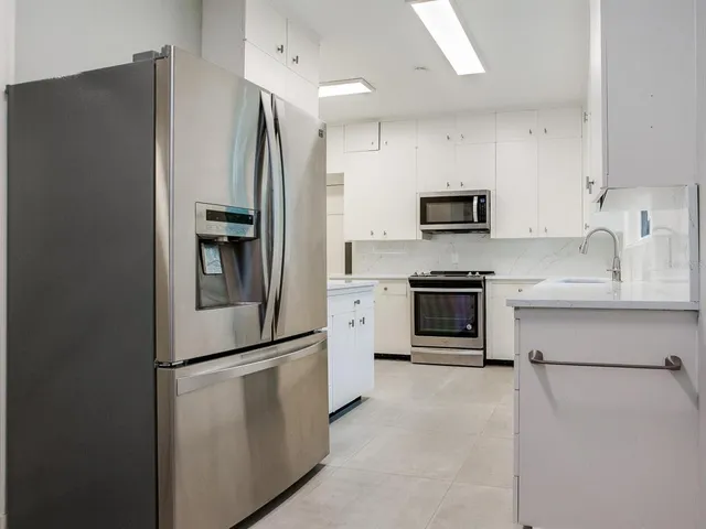 a kitchen with stainless steel appliances and refrigerator