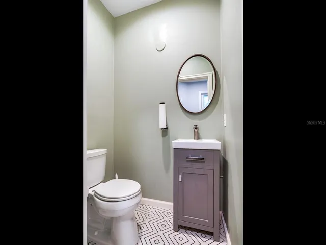 a bathroom with a toilet a sink and a mirror