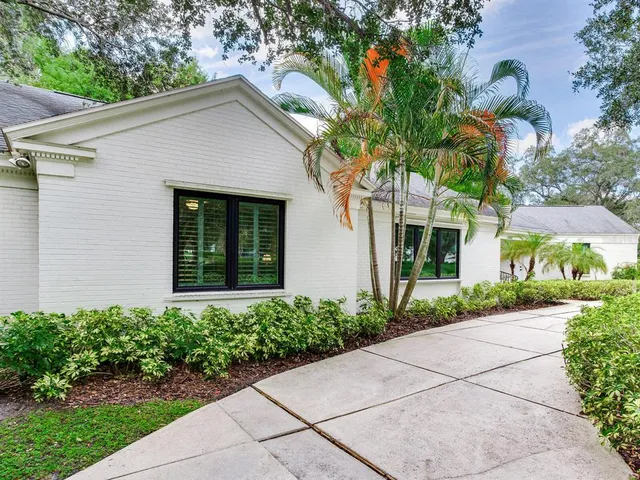 a front view of a house with a yard and potted plants