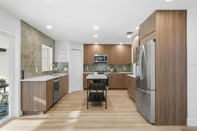 a kitchen with stainless steel appliances a sink stove and cabinets