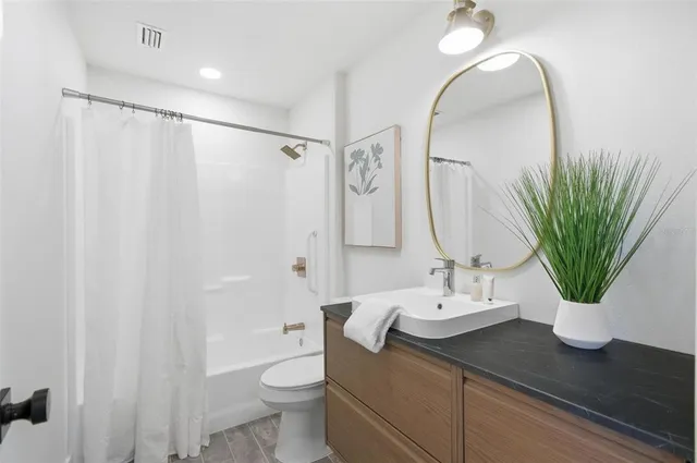 a bedroom with a bed and a painting on the wall