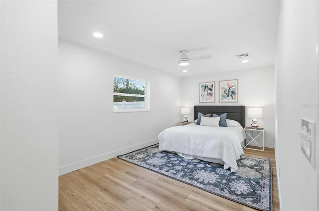 a bedroom with a large bed and a painting on the wall