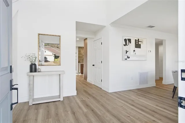 a view of a hallway with wooden floor and cabinet