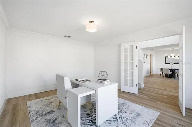 a view of a dining room with furniture a chandelier and wooden floor