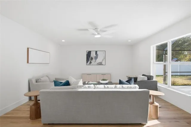 a living room with furniture and a view of kitchen