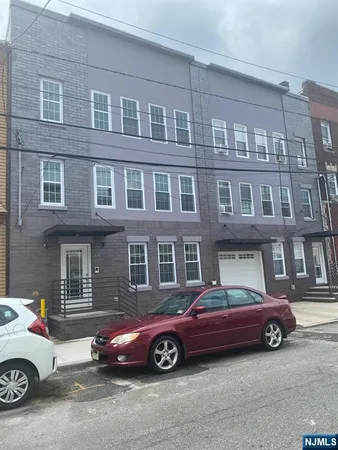 a car parked in front of a big house
