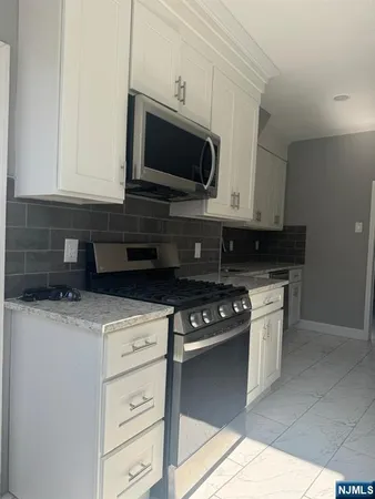 a kitchen with stainless steel appliances granite countertop a stove a microwave and oven