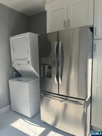 a view of a refrigerator in kitchen and an empty room