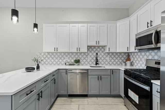 a kitchen with stainless steel appliances granite countertop a sink stove and microwave