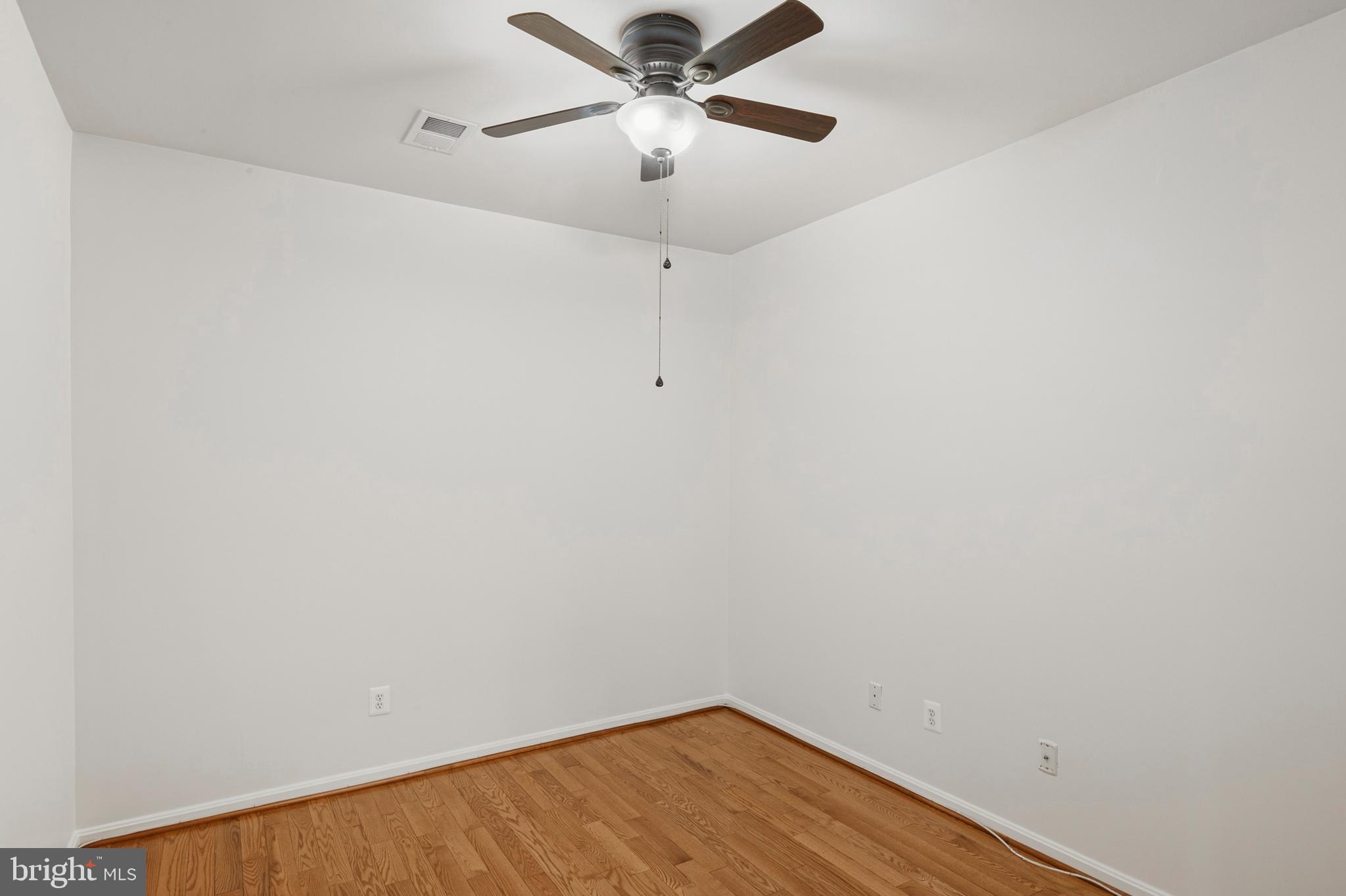 8601 Roaming Ridge Way, Unit 304 Odenton, MD 21113 - Photo 11 of 40 a view of a room with wooden floor and a ceiling fan