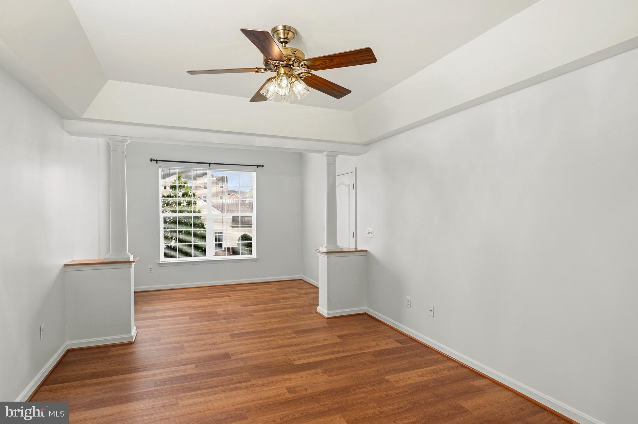 8601 Roaming Ridge Way, Unit 304 Odenton, MD 21113 - Photo 15 of 40 a view of an empty room with wooden floor and a window