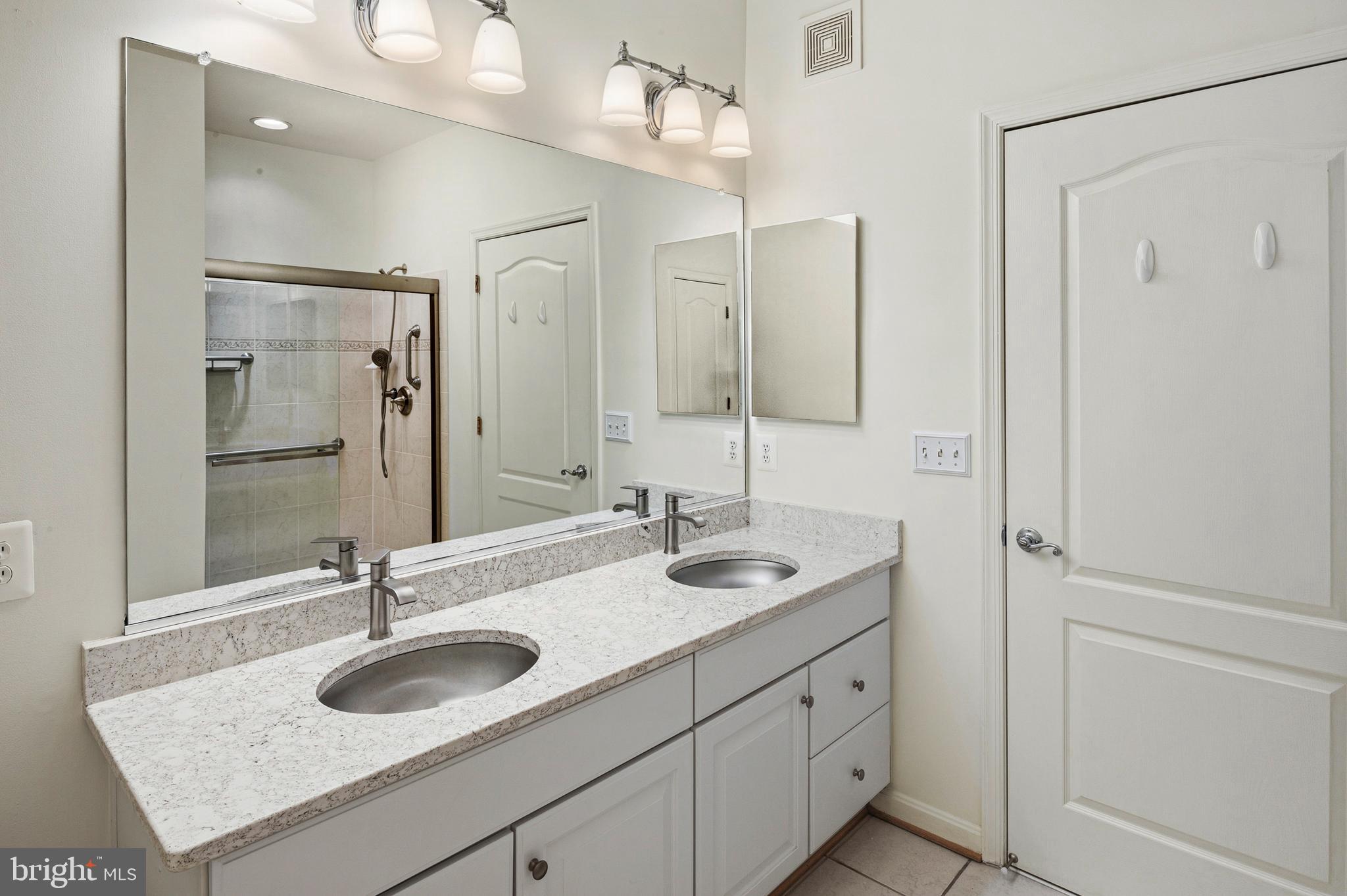 8601 Roaming Ridge Way, Unit 304 Odenton, MD 21113 - Photo 19 of 40 a bathroom with double sink and a mirror