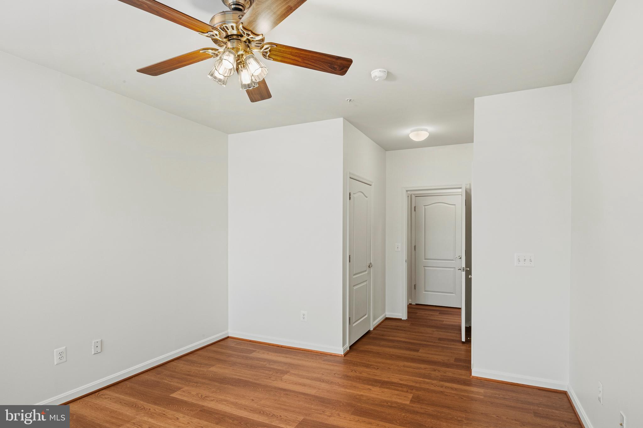 8601 Roaming Ridge Way, Unit 304 Odenton, MD 21113 - Photo 22 of 40 a view of a hallway with wooden floor
