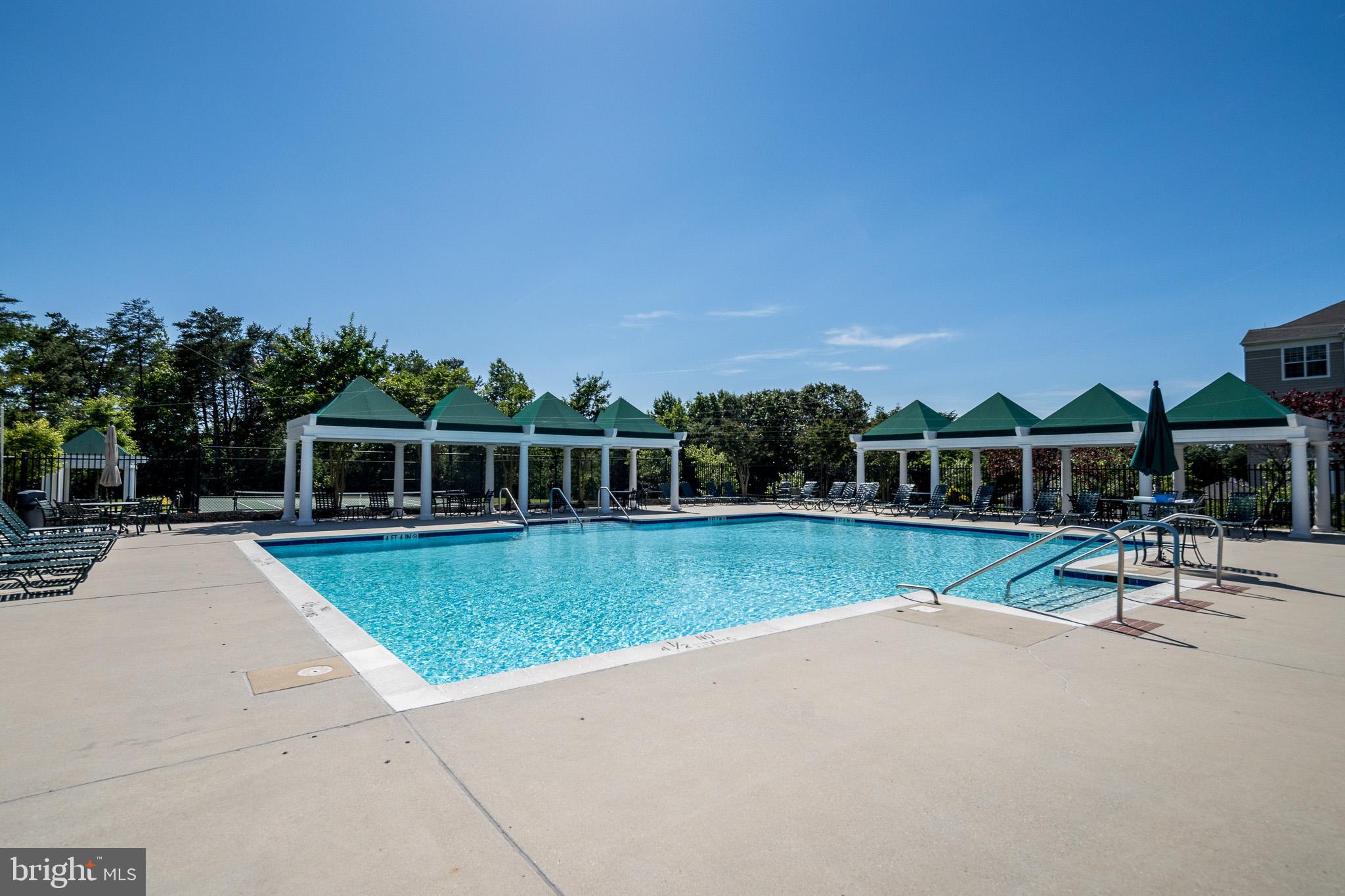 8601 Roaming Ridge Way, Unit 304 Odenton, MD 21113 - Photo 31 of 40 a view of a swimming pool with a table and chairs