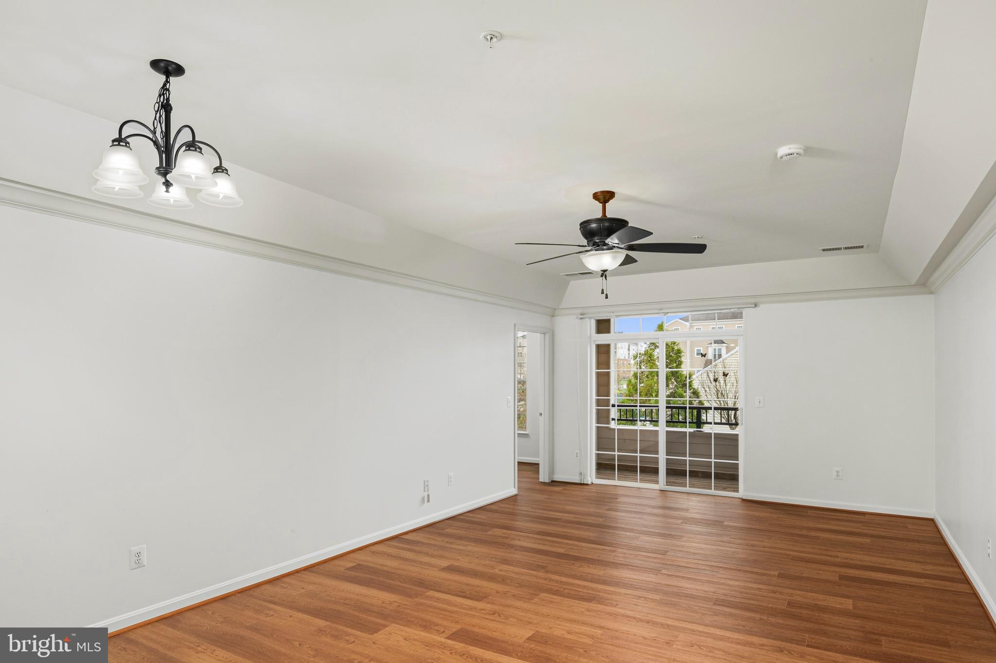 8601 Roaming Ridge Way, Unit 304 Odenton, MD 21113 - Photo 6 of 40 a view of a livingroom with wooden floor and a ceiling fan