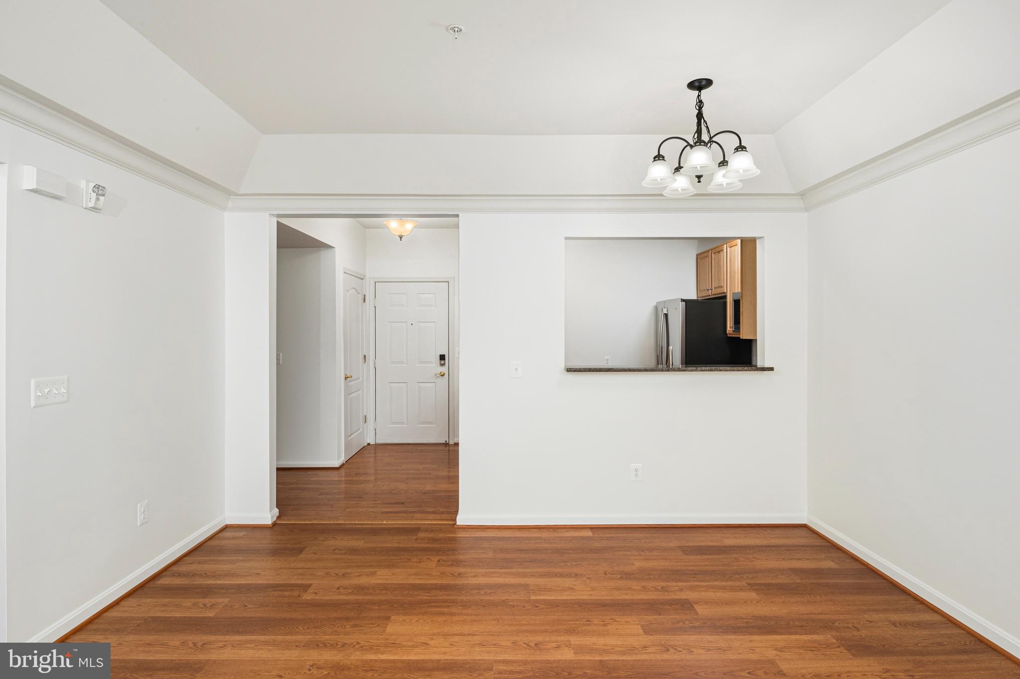 8601 Roaming Ridge Way, Unit 304 Odenton, MD 21113 - Photo 7 of 40 a view of an empty room with wooden floor and a hallway