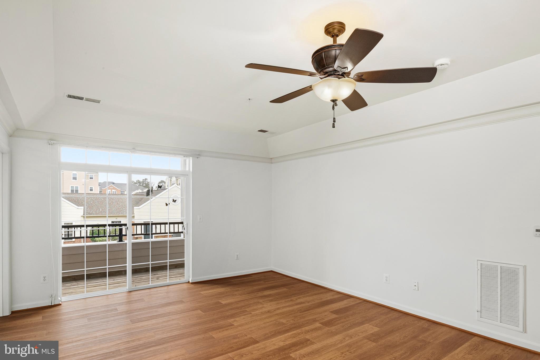 8601 Roaming Ridge Way, Unit 304 Odenton, MD 21113 - Photo 8 of 40 a view of a room with wooden floor and ceiling fan