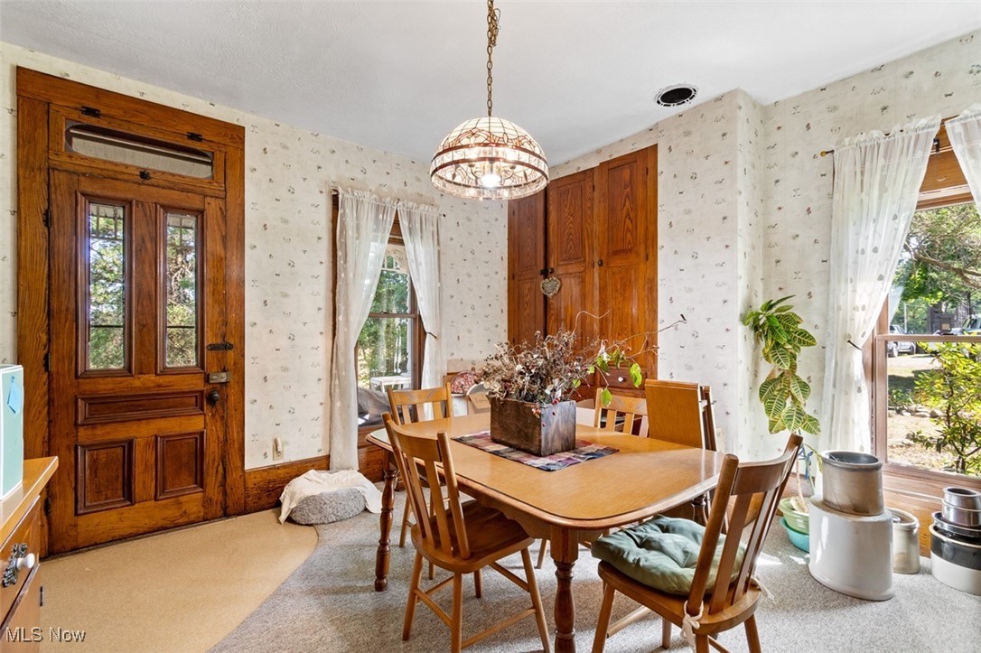 13642 Navarre Road Southwest Beach City, OH 44608 - Photo 10 of 33 Carpeted dining room featuring an inviting chandelier and plenty of natural light