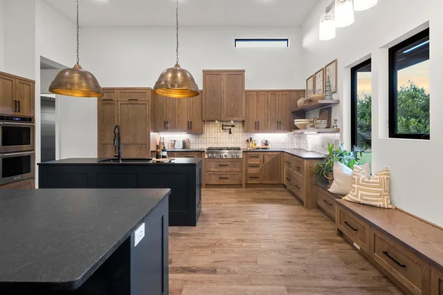 a kitchen with stainless steel appliances granite countertop a sink a stove and a wooden floors