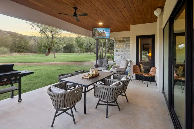 a view of a patio with table and chairs under an umbrella