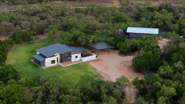 an aerial view of a house with a yard