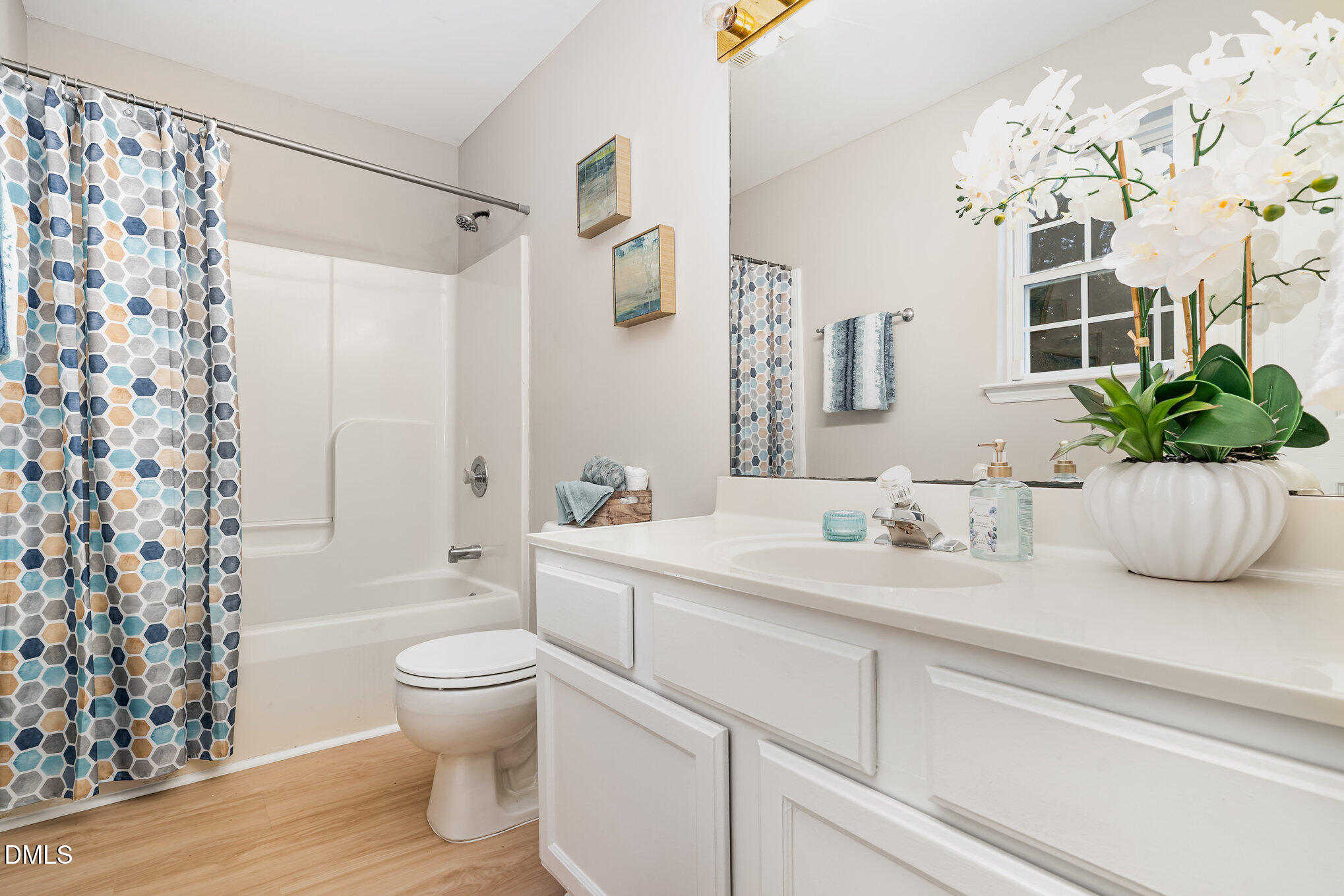 5414 Stanley Road Durham, NC 27704 - Photo 11 of 20 a bathroom with a sink a toilet and a large mirror