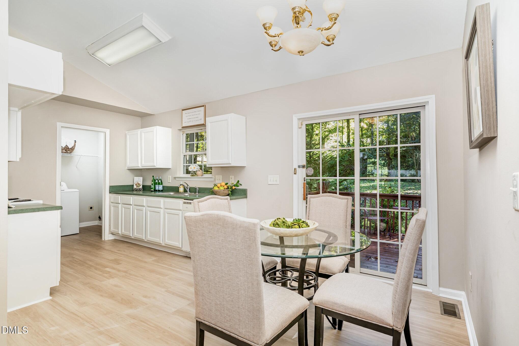 5414 Stanley Road Durham, NC 27704 - Photo 4 of 20 a kitchen with a dining table chairs and refrigerator