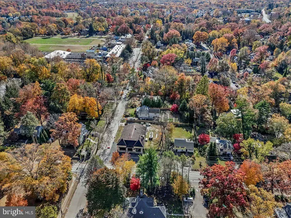 an aerial view of residential houses with outdoor space and trees