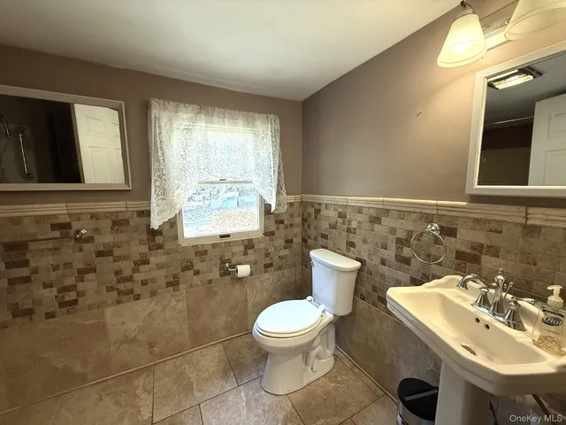 a bathroom with a toilet sink and mirror