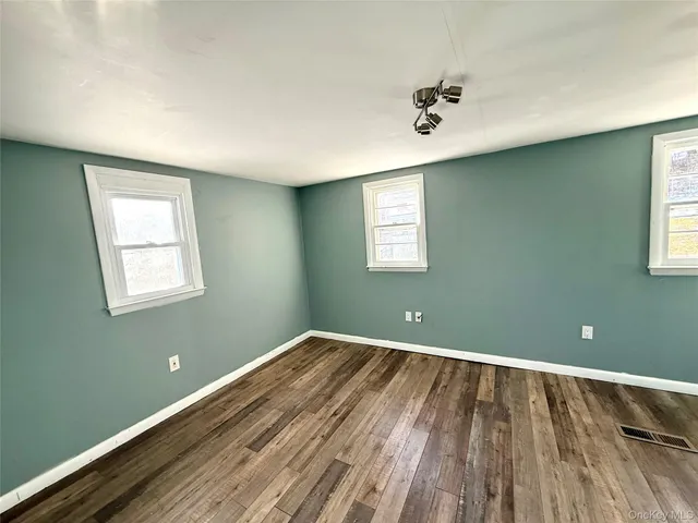 a view of a room with wooden floor and a window