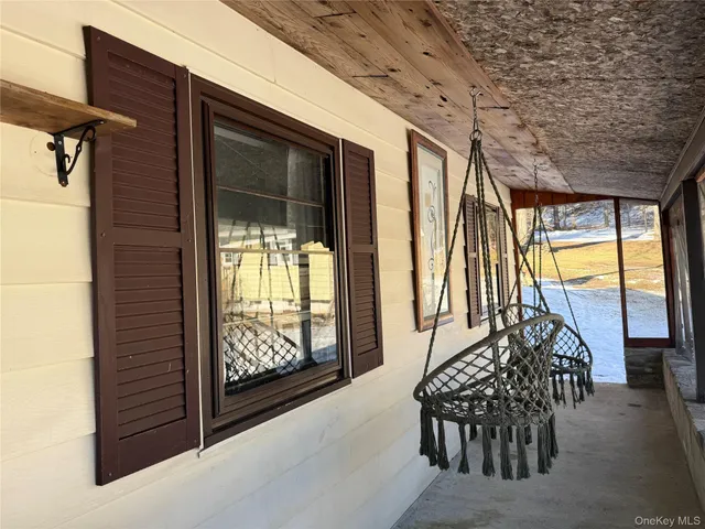 a view of porch with furniture and next to a window