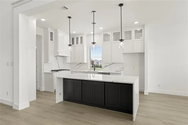 a large kitchen with stainless steel appliances sink refrigerator and cabinets
