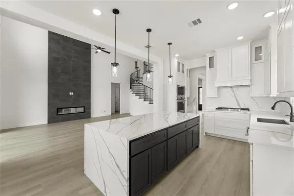 a kitchen with white cabinets and appliances