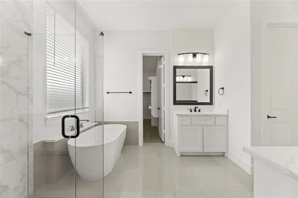 a bathroom with a double vanity sink mirror and a bathtub