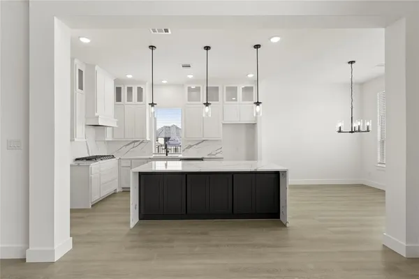 a kitchen with kitchen island white cabinets and sink