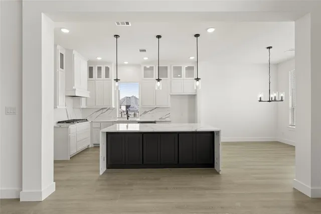 a kitchen with kitchen island white cabinets and sink