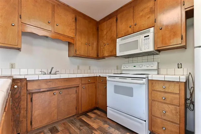 a kitchen with stainless steel appliances granite countertop a sink stove and cabinets