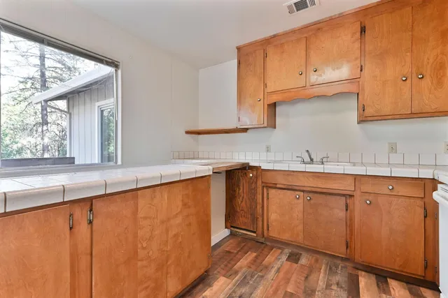 a kitchen with granite countertop wooden cabinets a sink and dishwasher