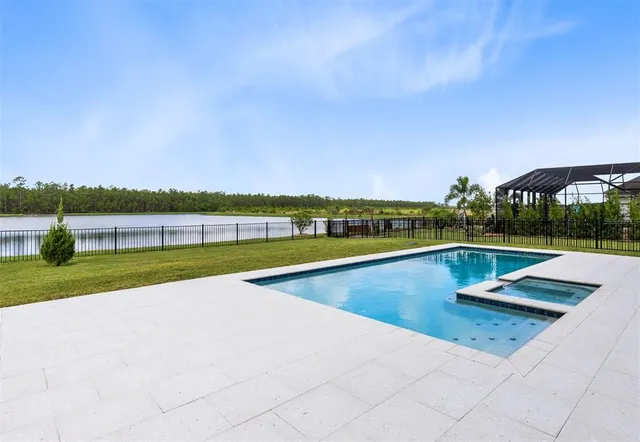a view of swimming pool with seating area and mountains in the background