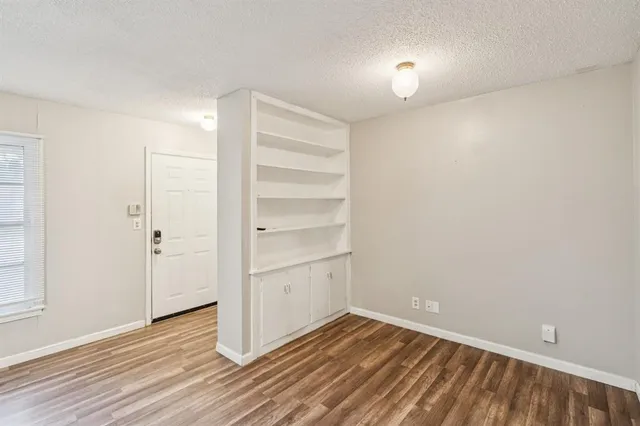 a view of a room with wooden floor and white walls