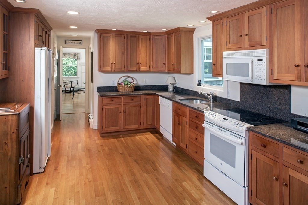 40 Union Hall Road Duxbury, MA 02332 - Photo 4 of 18 a kitchen with stainless steel appliances granite countertop hardwood floor sink stove and wooden cabinets