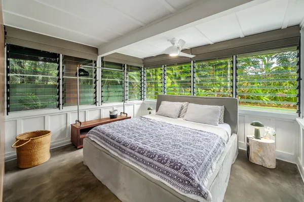 a bedroom with a bed and large windows