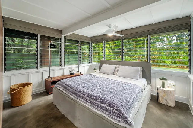 a bedroom with a bed and large windows