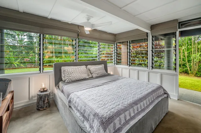 a bedroom with a bed and a large window with outer view