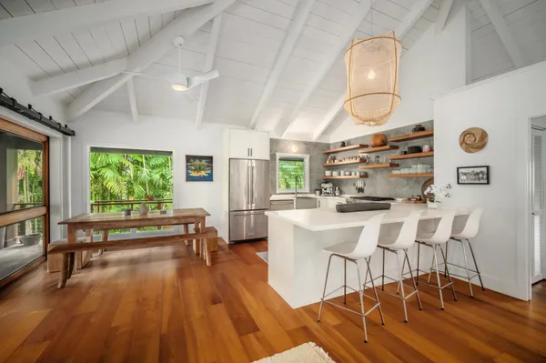 a dining room with wooden floor a chandelier a wooden table and chairs