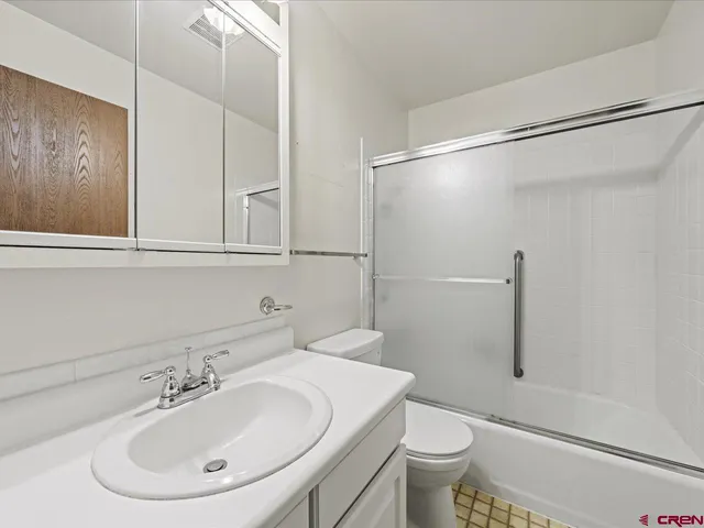 an empty room with a ceiling fan and wooden floor