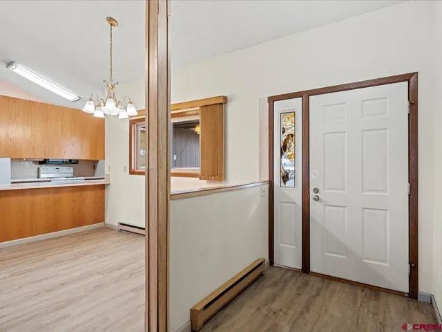 a view of a kitchen with a sink wooden floor a refrigerator and a counter top
