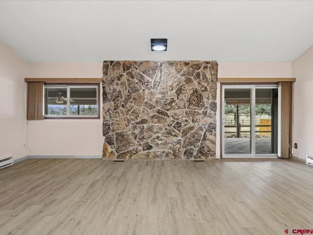a view of empty room with wooden floor and door
